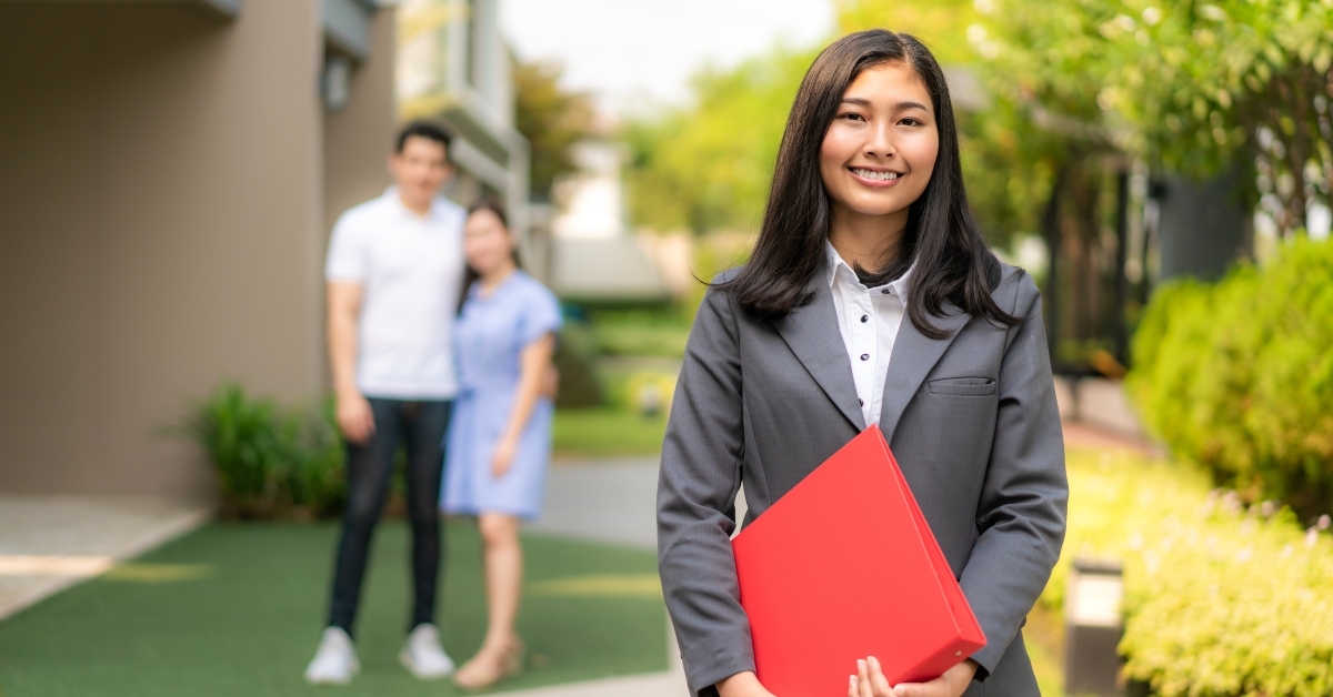 realtor in suit holding red file