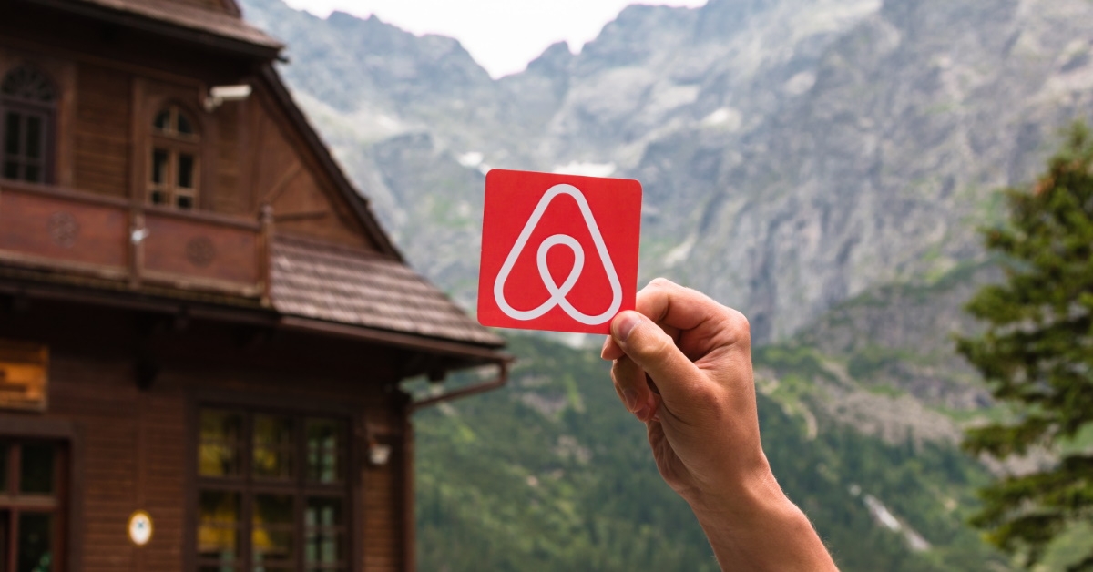 man holding sign reading airbnb