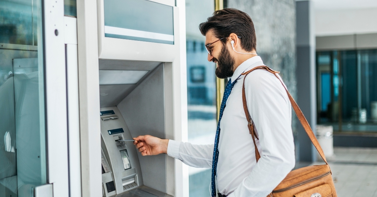Businessman using card at an ATM