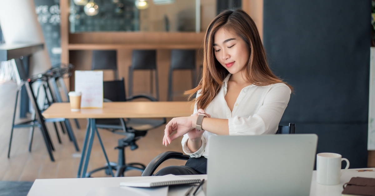 businesswoman sitting in office looking at watch