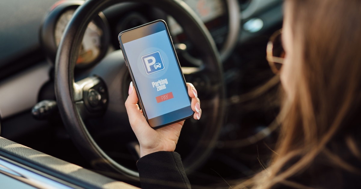 girl using smartphone app to pay for the parking