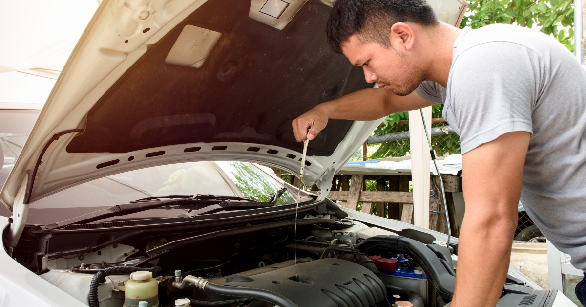 man checking car engine at home