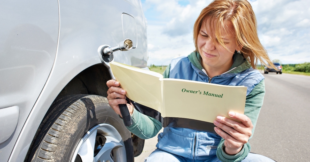 woman reading owner's manual of car
