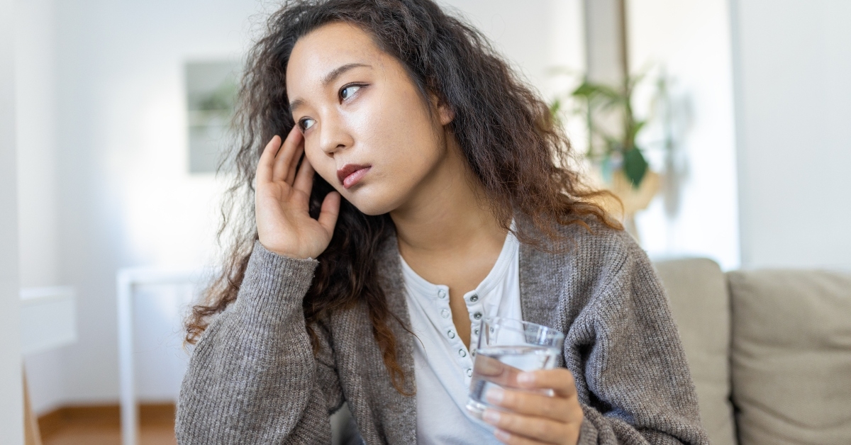 sad woman holding her head because of sinus pain