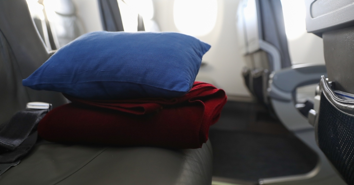 pillow and blanket lying on the seat in the plane
