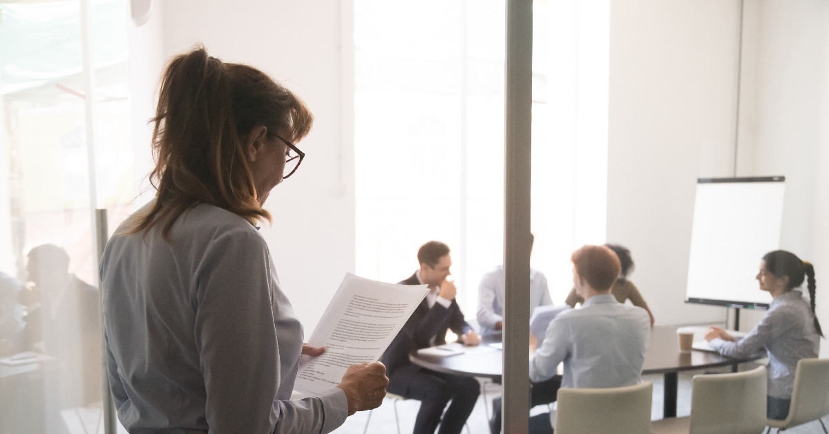 businesswoman in workplace looking at papers in hand