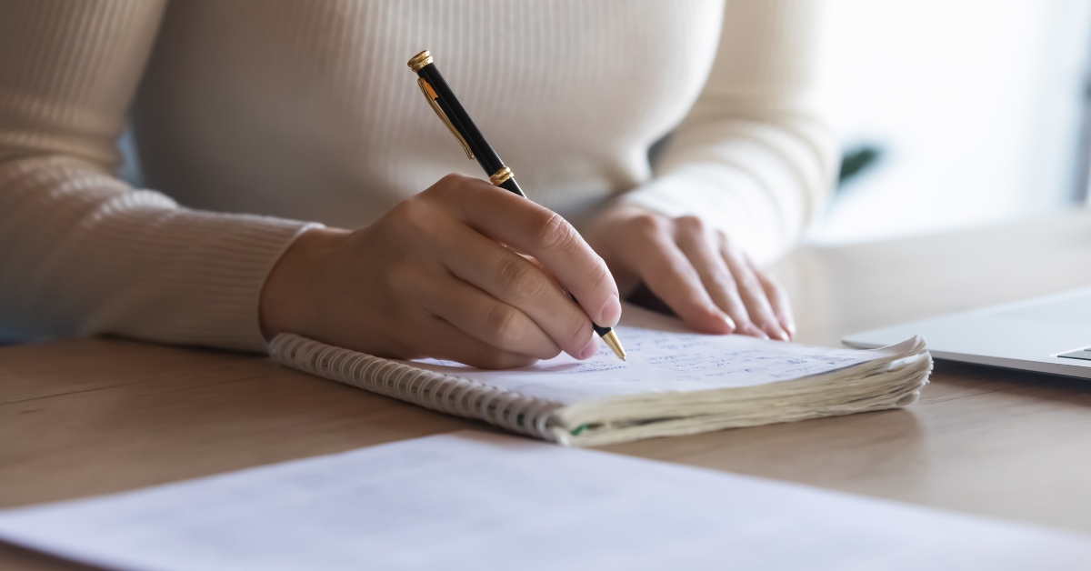 female student makes notes on exercise book