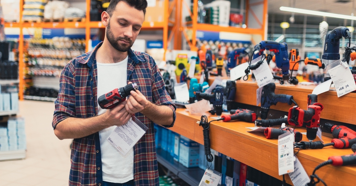 man in a hardware store chooses a new screwdriver