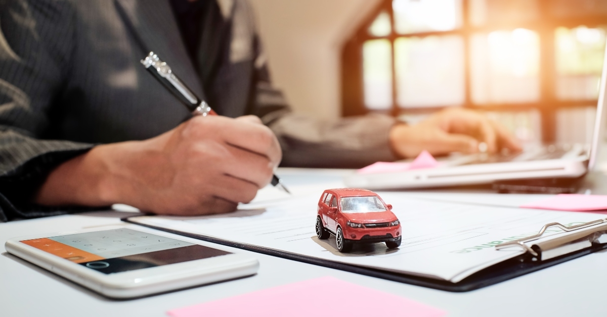man signing an auto car insurance