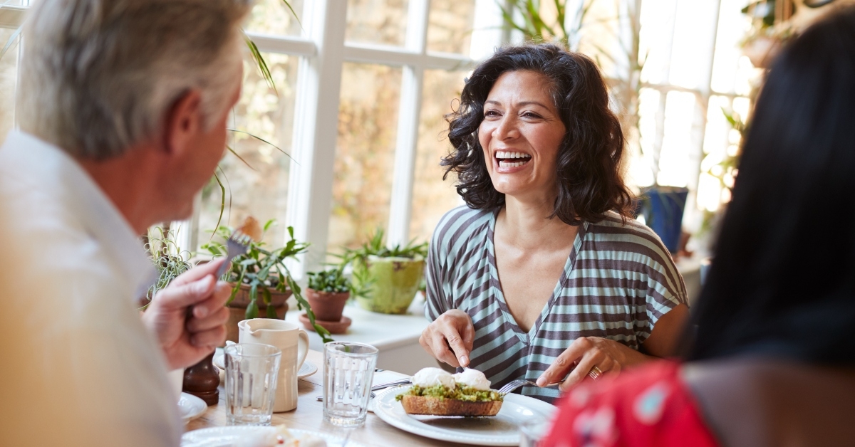 woman laughing with male friend at a cafe