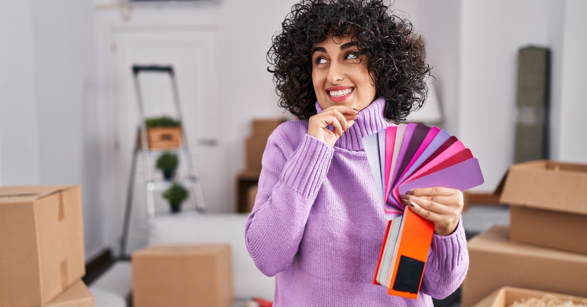 woman with curly hair choosing color of new house wall