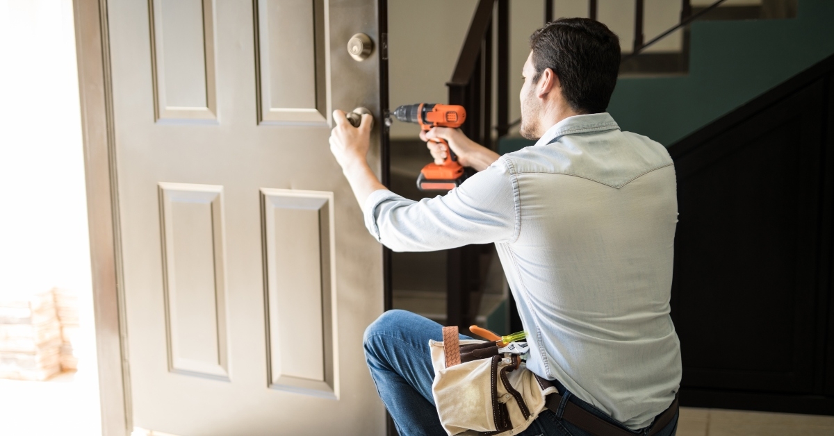man fixing a door lock