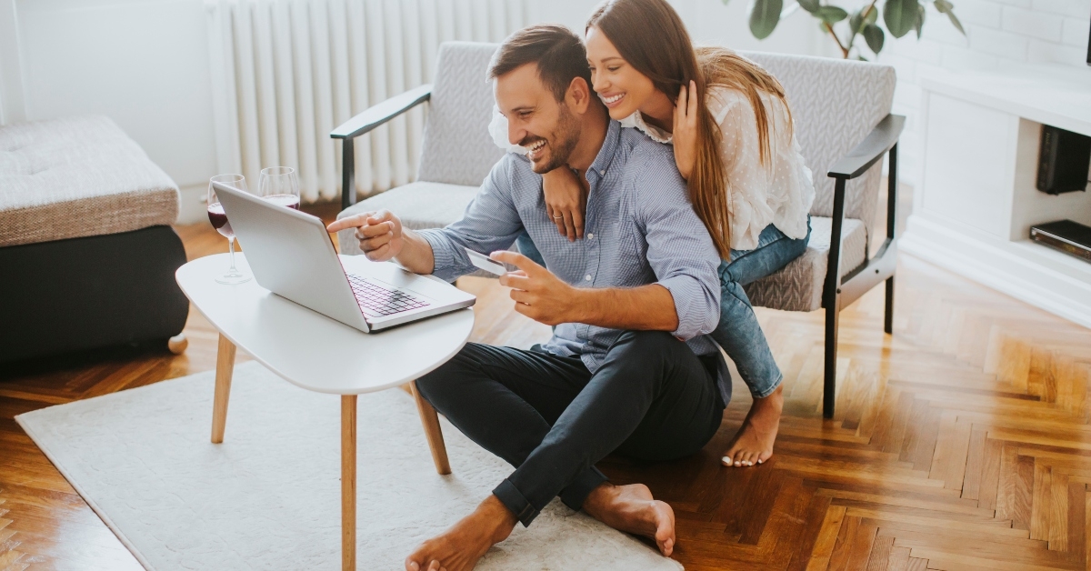 couple searching internet on laptop at home