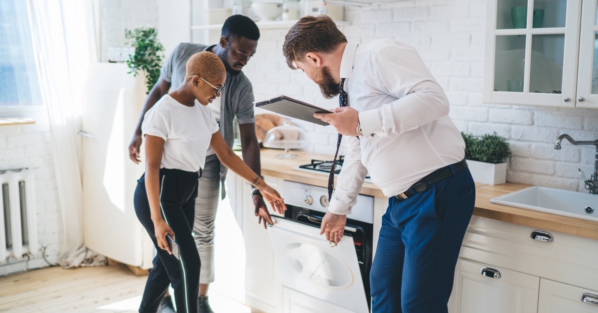 estate agent showing kitchen to couple