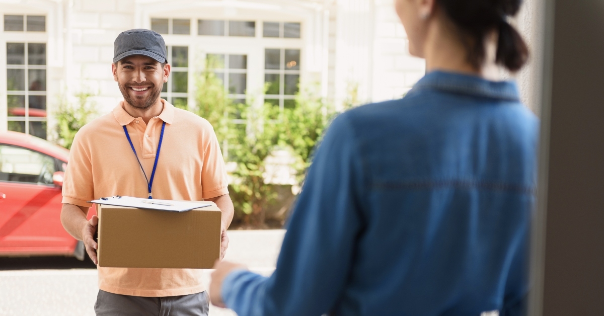 courier making delivery to beautiful woman