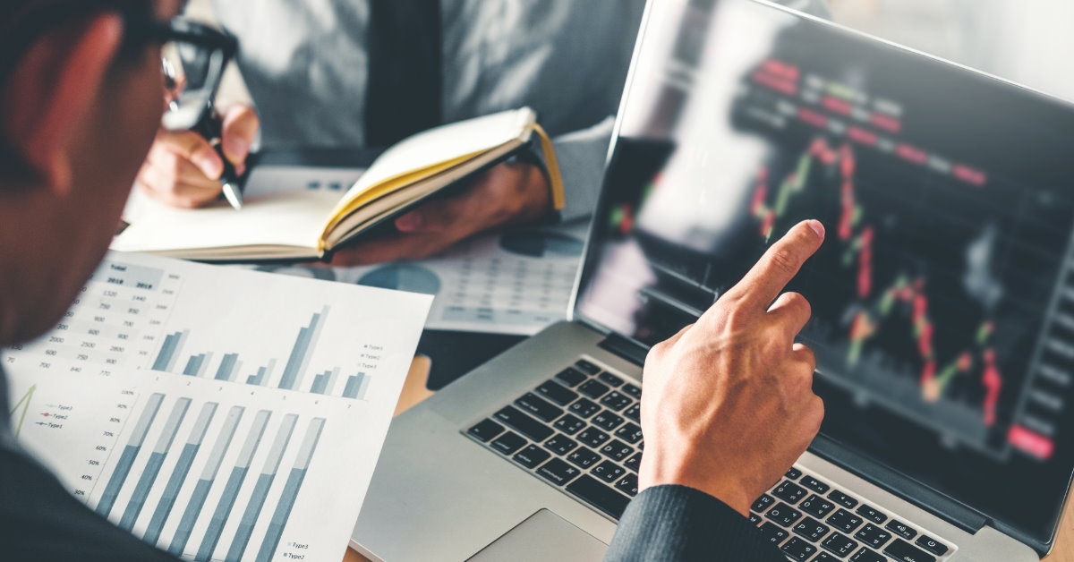entrepreneur checking stock market graphs on laptop