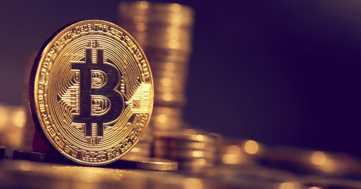 golden bitcon standing still in front of stack of bitcoins