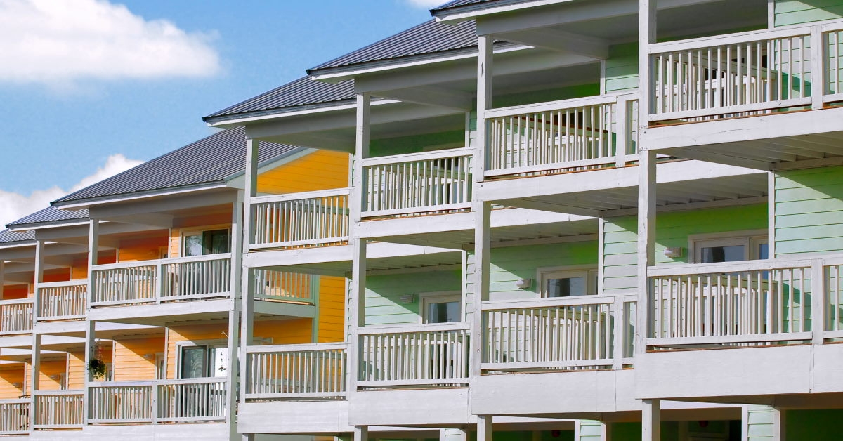colorful tropical townhomes with white balconies and grey rooftops
