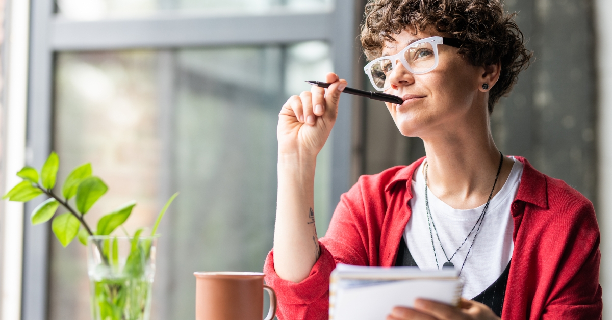 pensive female in eyeglasses thinking of new creative ideas