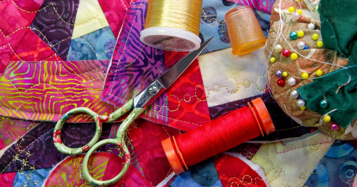 scissor and yard on colorful fabric cutouts with sewing essentials