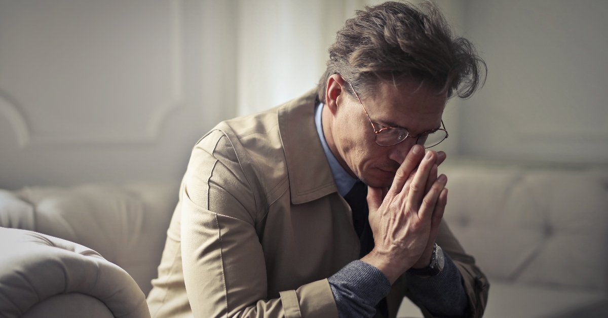 middle-aged businessman sitting on a couch and feeling stressed about work