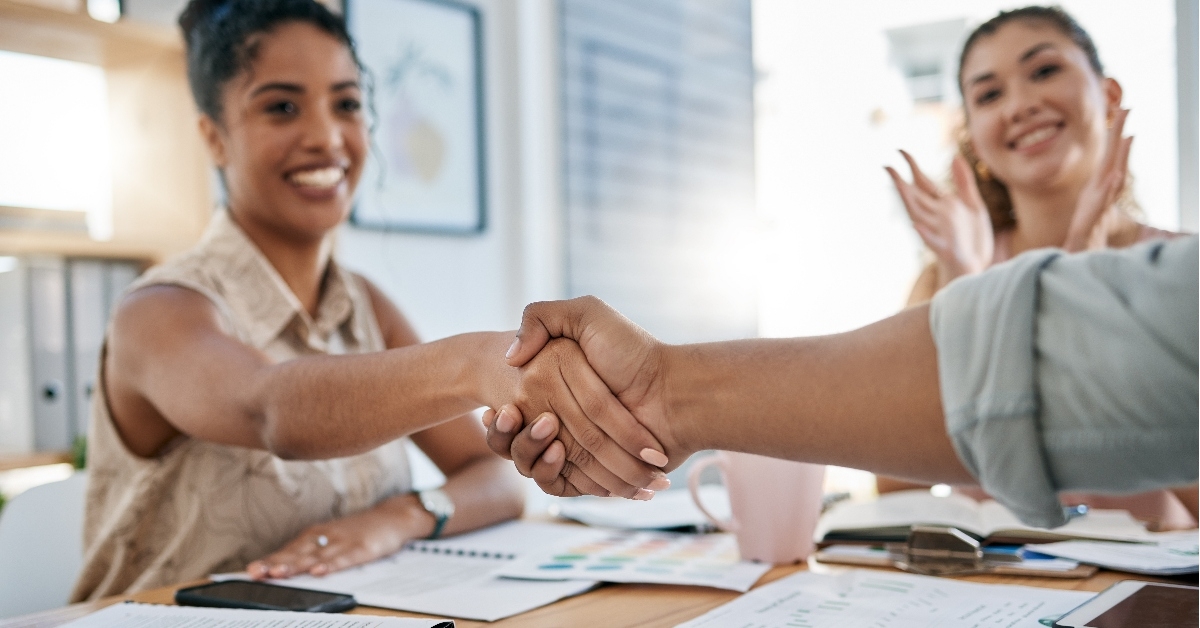 woman shaking hand with male coworker