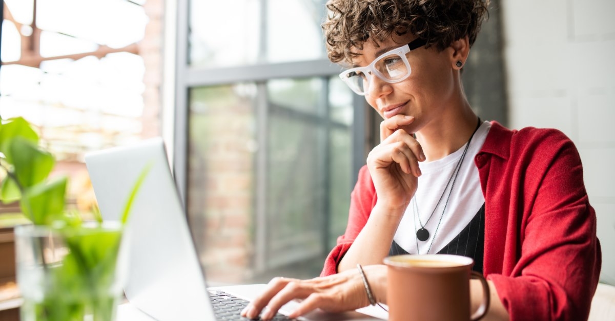 elegant woman sitting at table using laptop