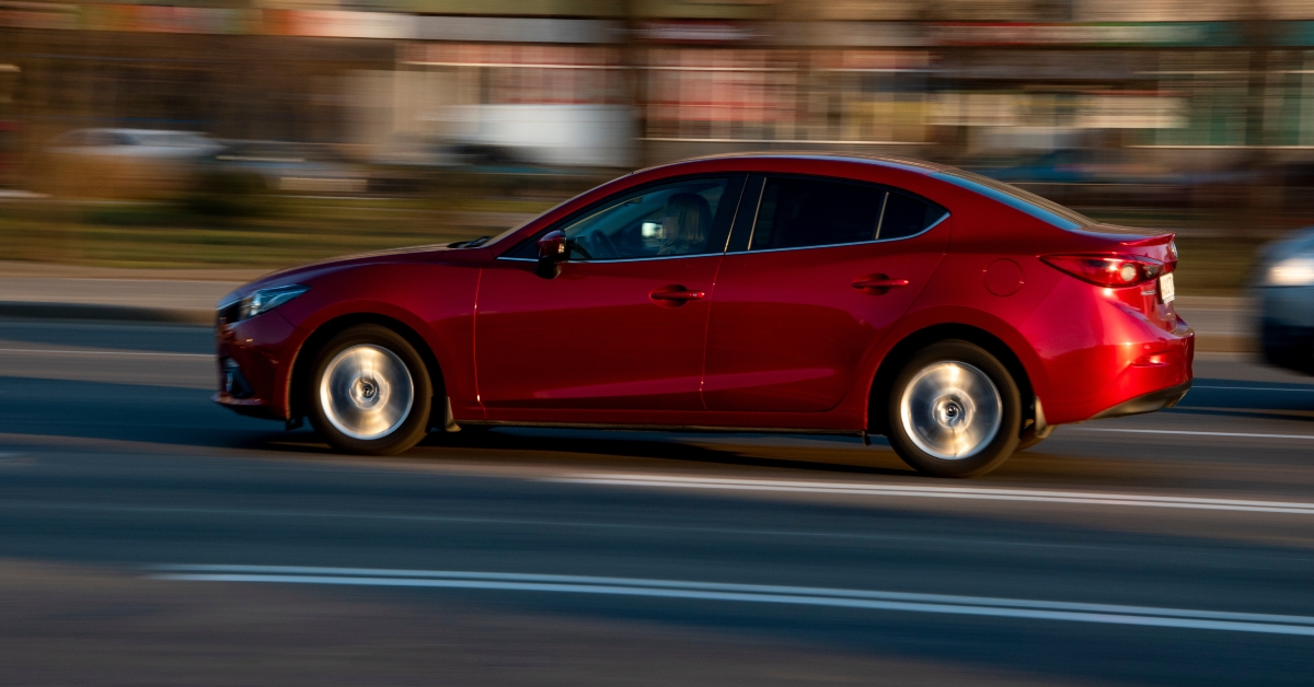 Red Mazda 3 car moving on the street
