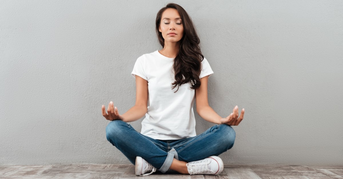 young asian woman meditating at home