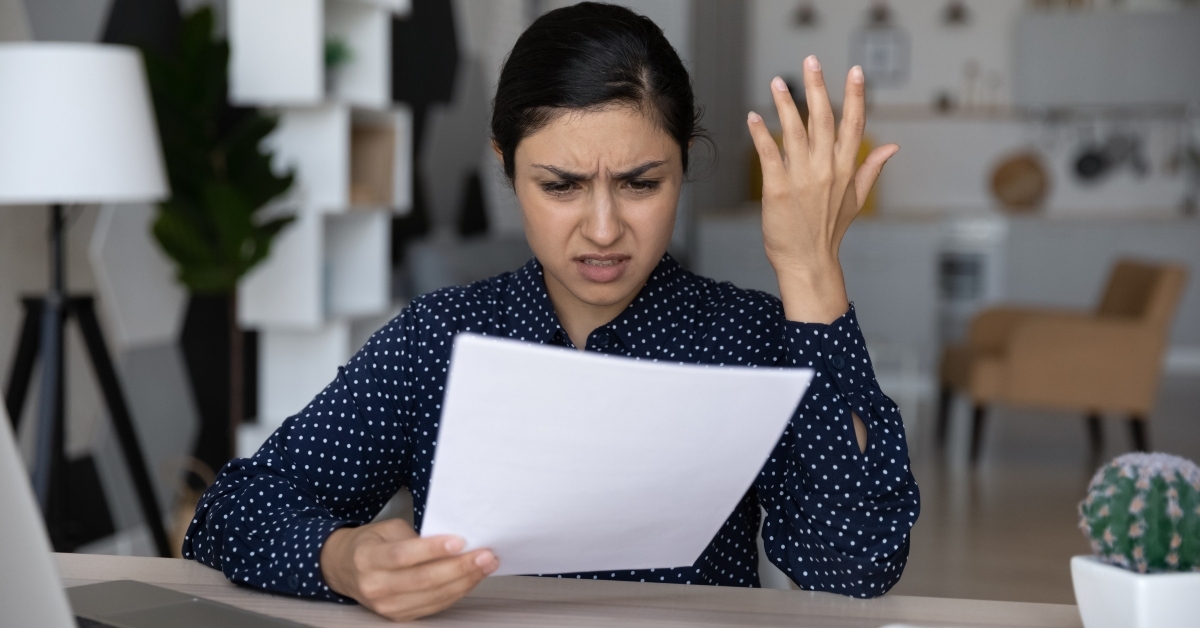 annoyed woman reading bad news in letter