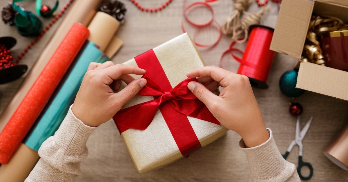 hands tying a bow on a gift