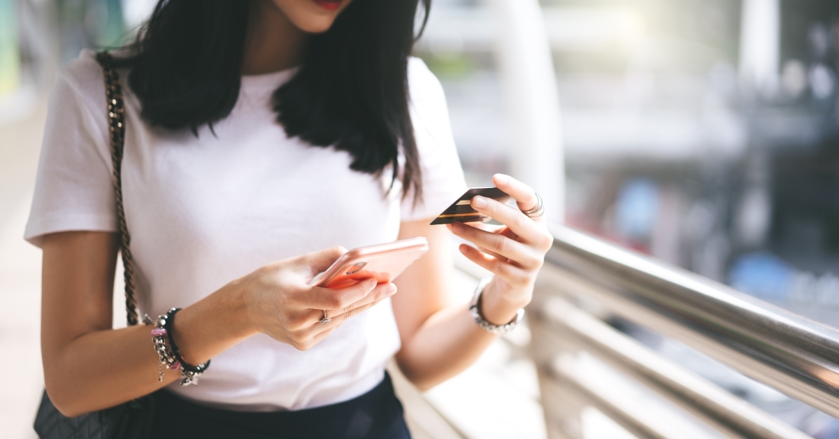 female consumer using credit card and smartphone