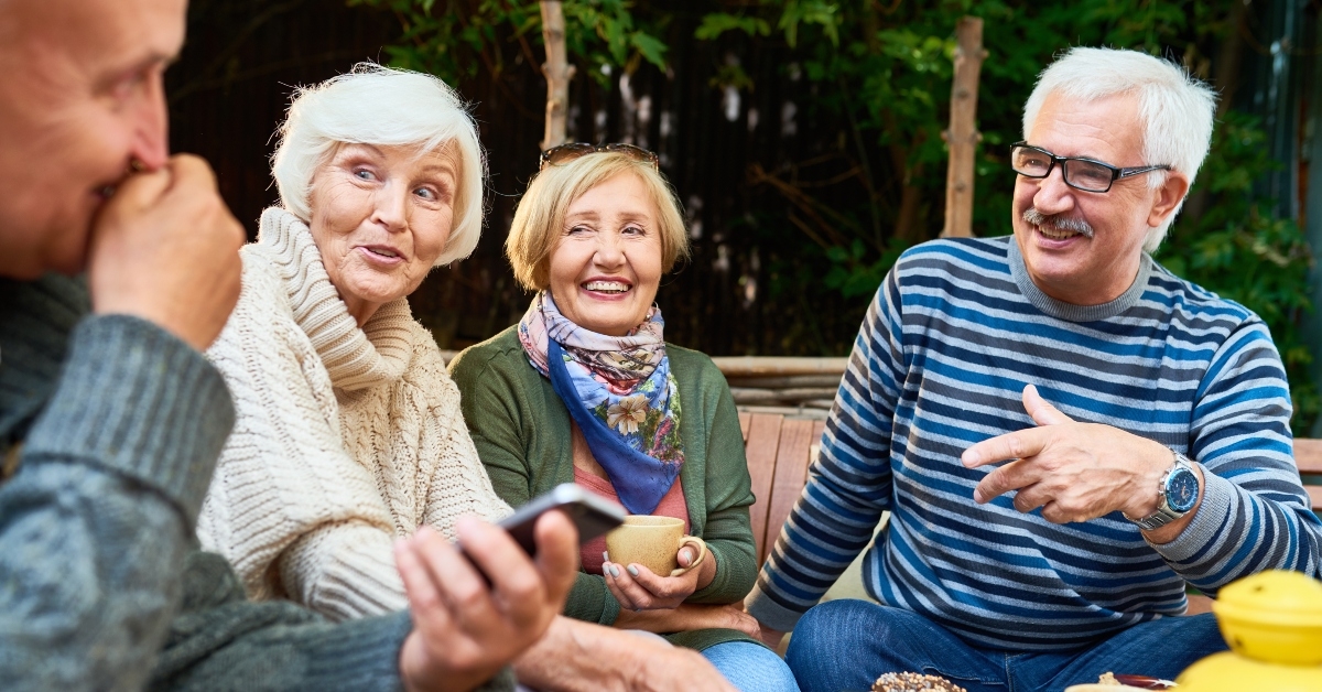 cheerful seniors enjoying time together drinking tea