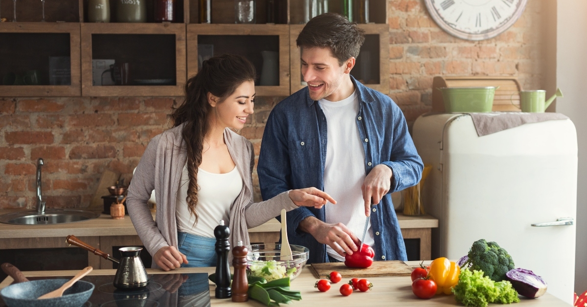 happy couple cooking dinner together