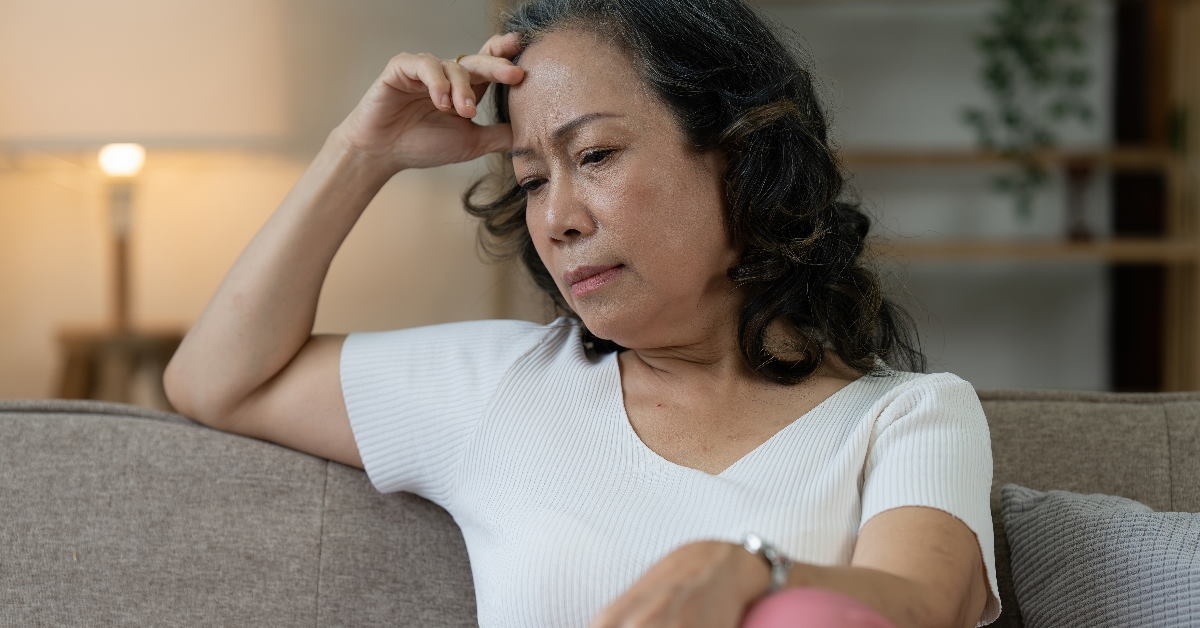 senior woman at home sitting on couch thinking about something
