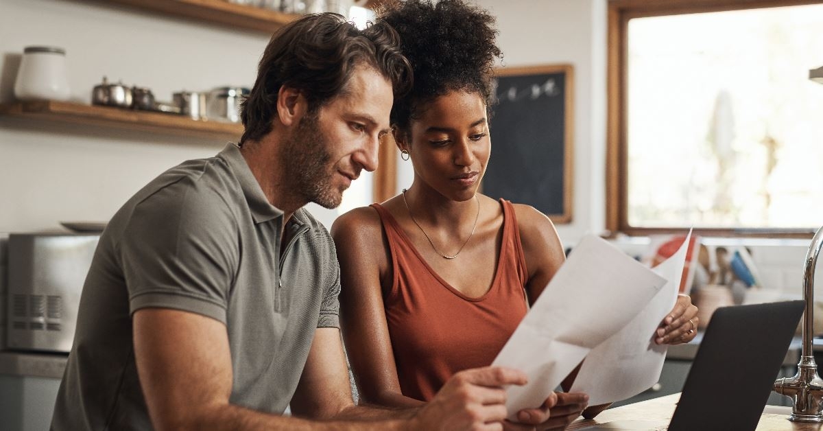 couple sitting in kitchen reviewing documents