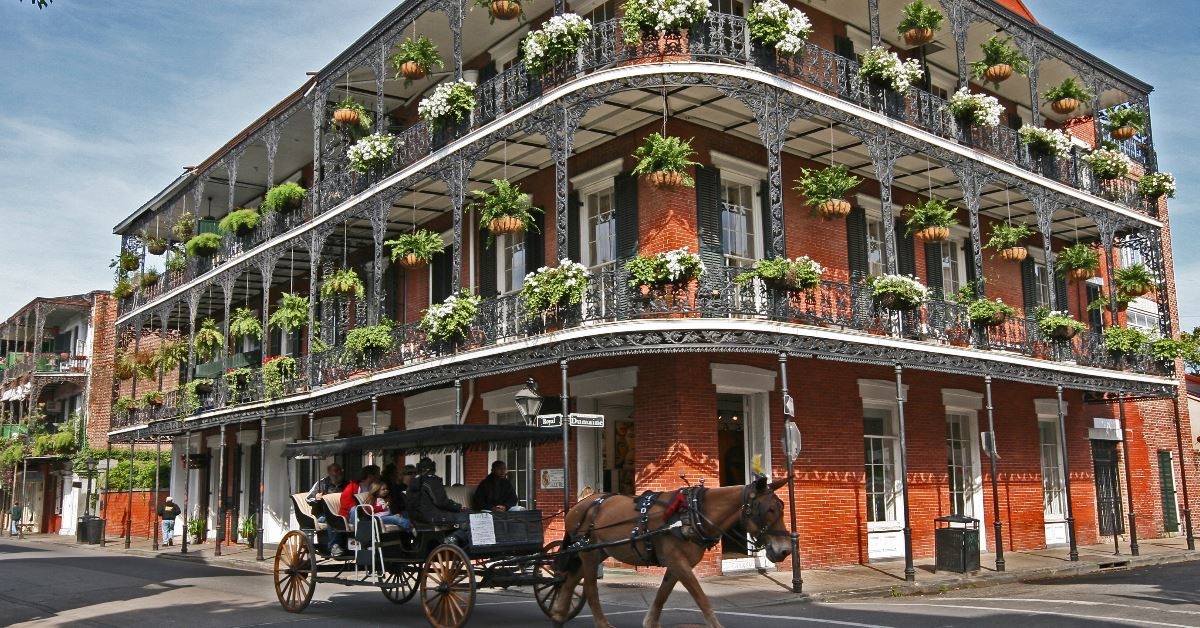 tourists riding in french quarter carriage in beautiful street