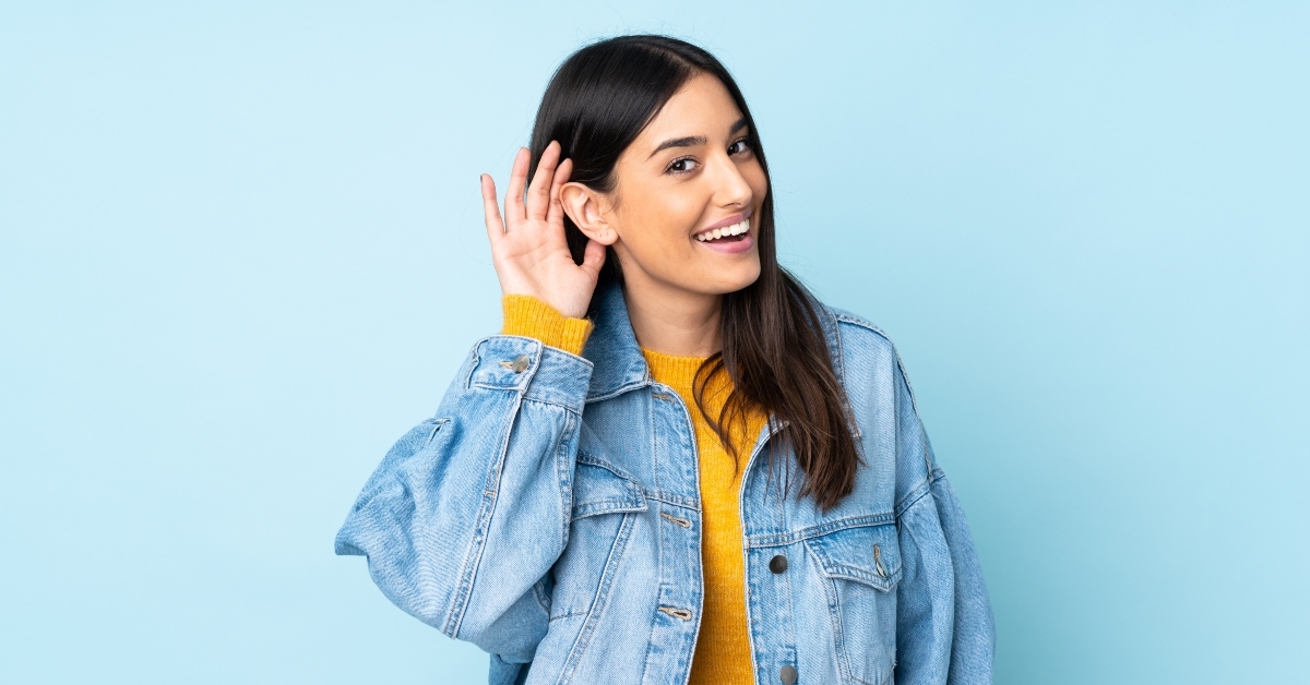 woman isolated on blue background listening to something