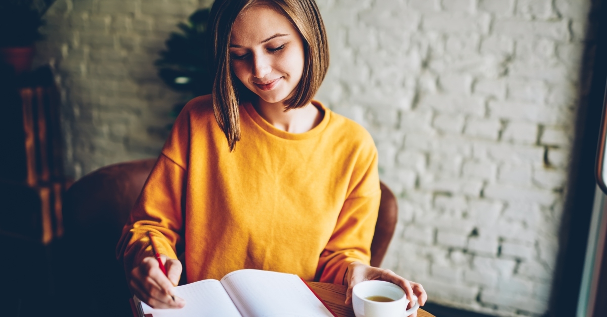 woman writing down future plans and goals in own diary