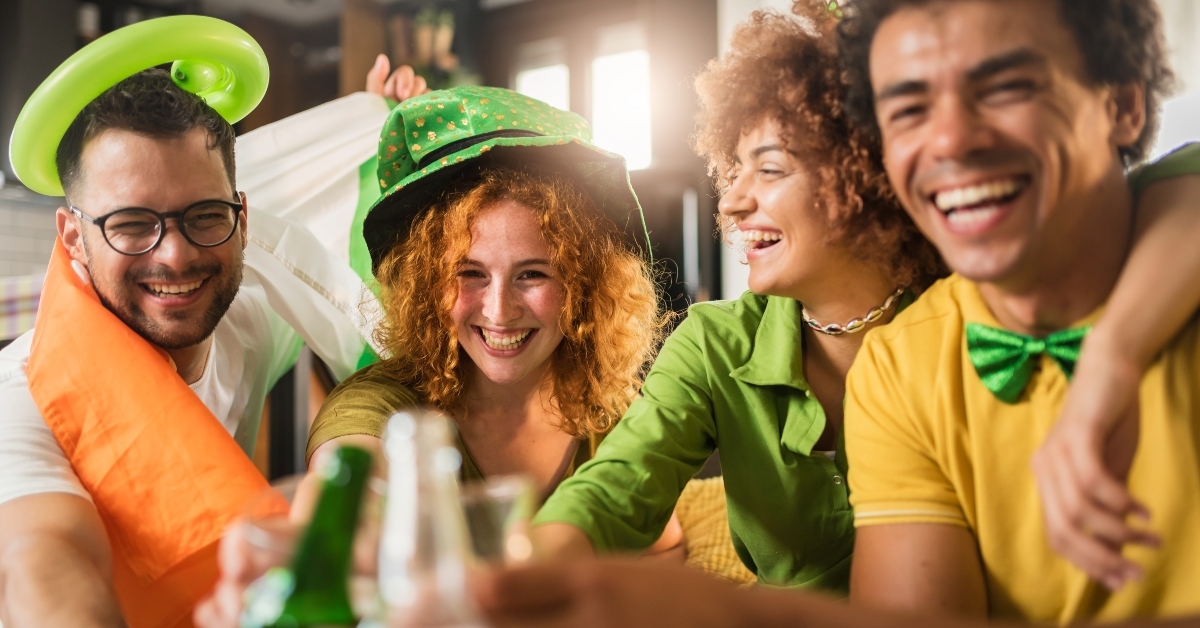 4 friends cheering dressed in green and yellow celebrating St. Patty's Day