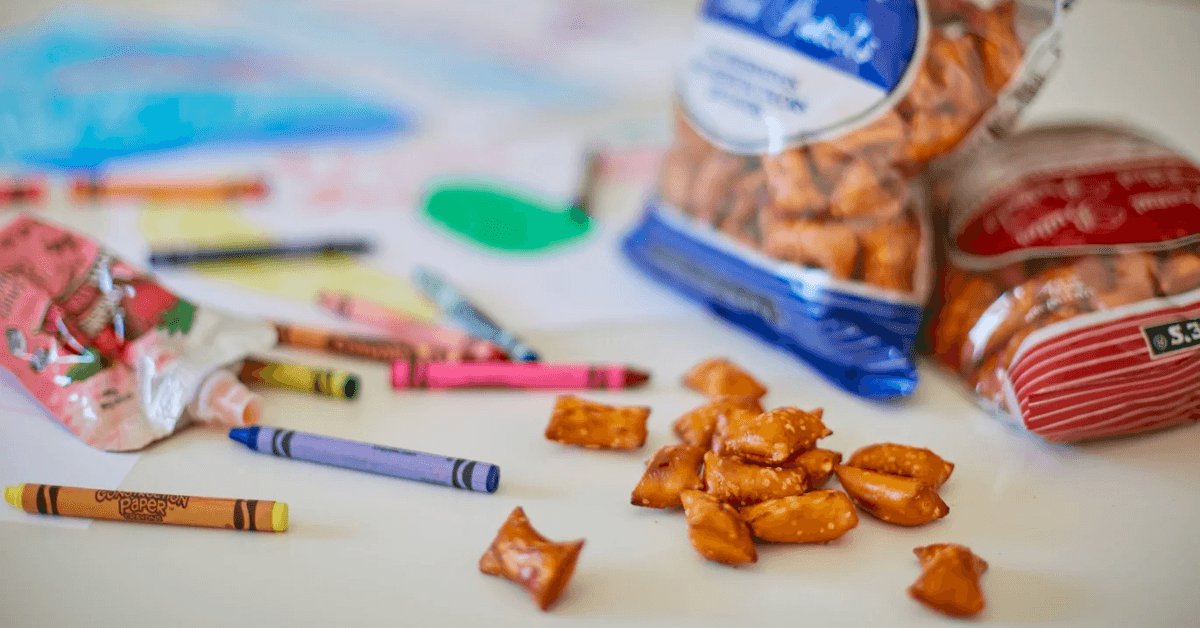 peanut butter filled pretzels from Trader Joe's on a table with color crayons spread 