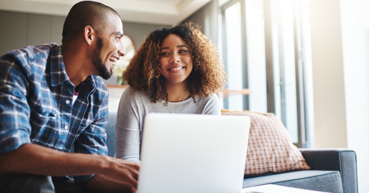 cheerful couple browsing on laptop