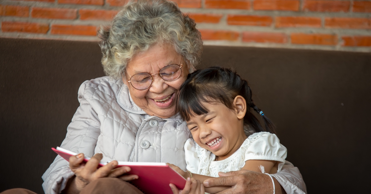 grandmother reading to granddaughter child book