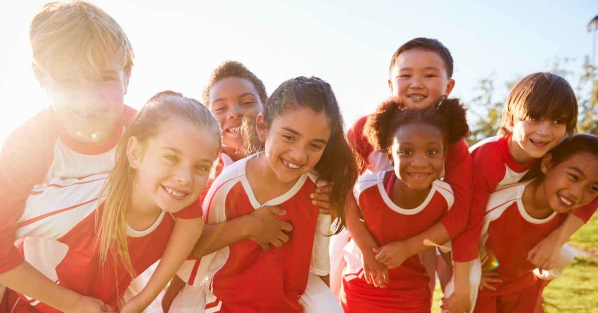 kids in elementary school sports team piggybacking