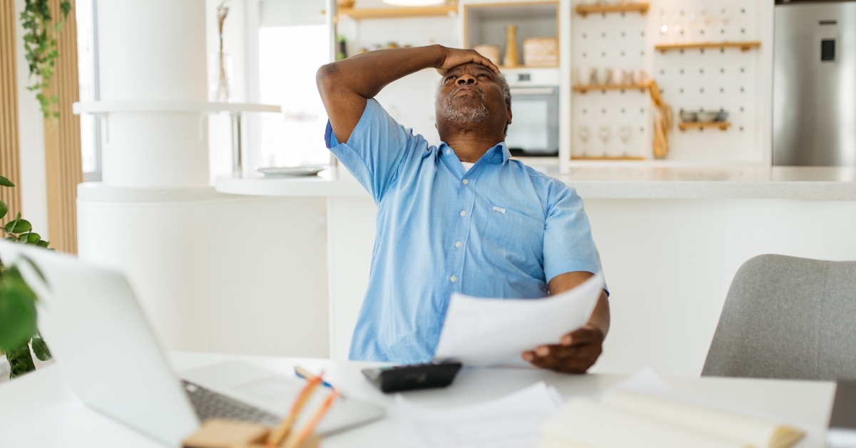 nervous senior man tapping hand on his forehead