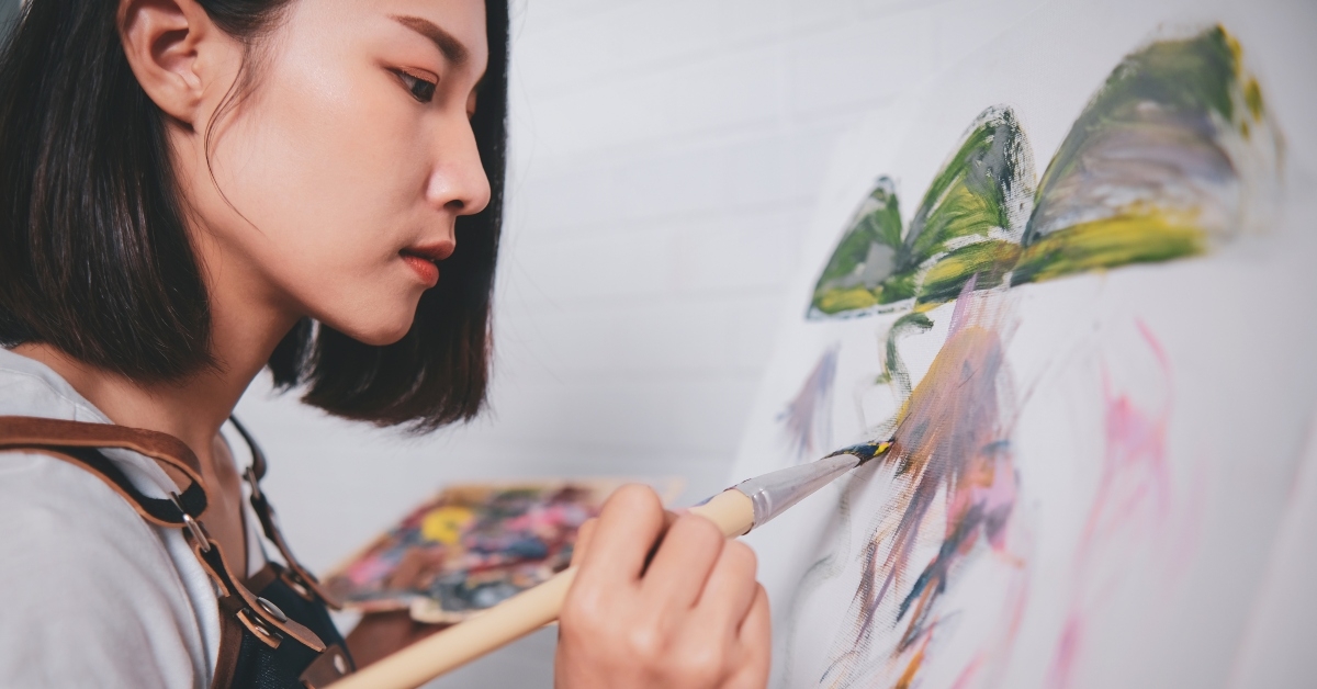 woman artist painting picture with blank canvas