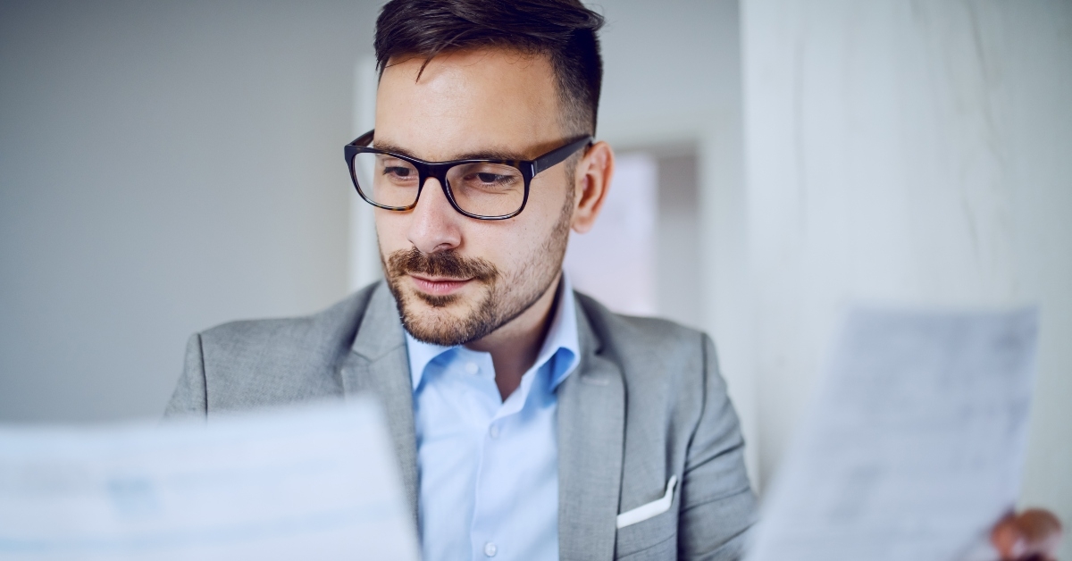 businessman in suit and with eyeglasses looking at documents