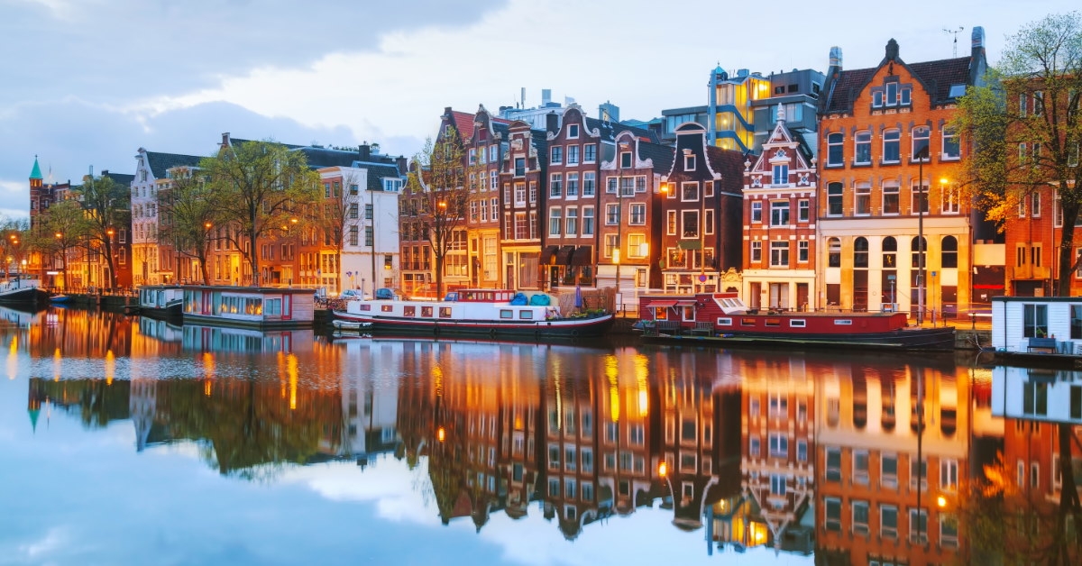 colorful building at water coast with boats in amsterdam netherlands