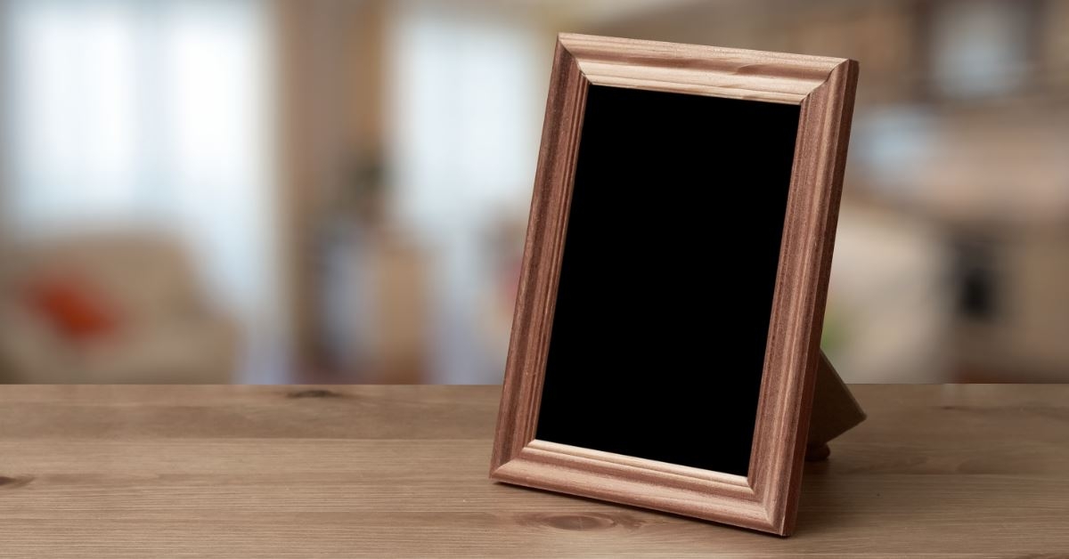 copper photo frame with black picture on rustic wooden table