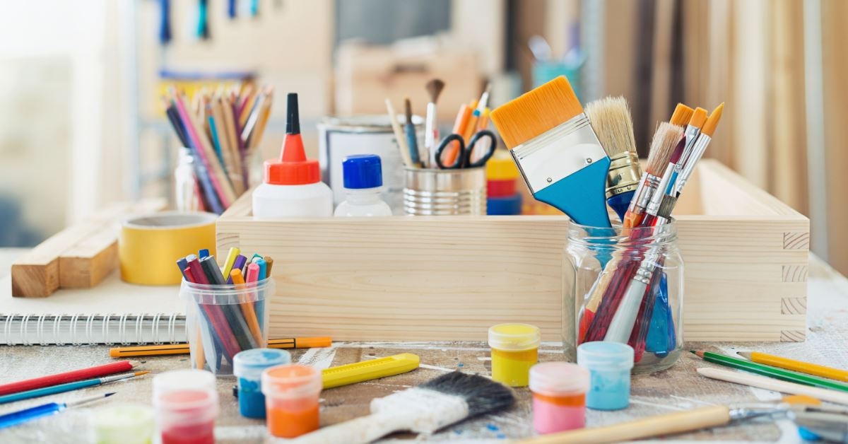 painting brushes and crafting supplies organized in wooden containers
